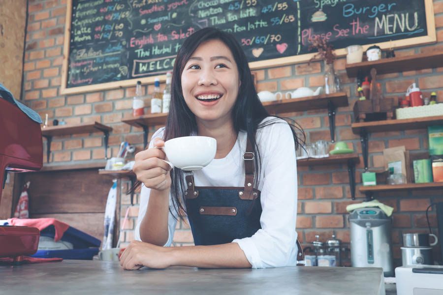 North Carolina Insurance - Small Business Owner Holding a Cup of Coffee in Her Coffee Shop